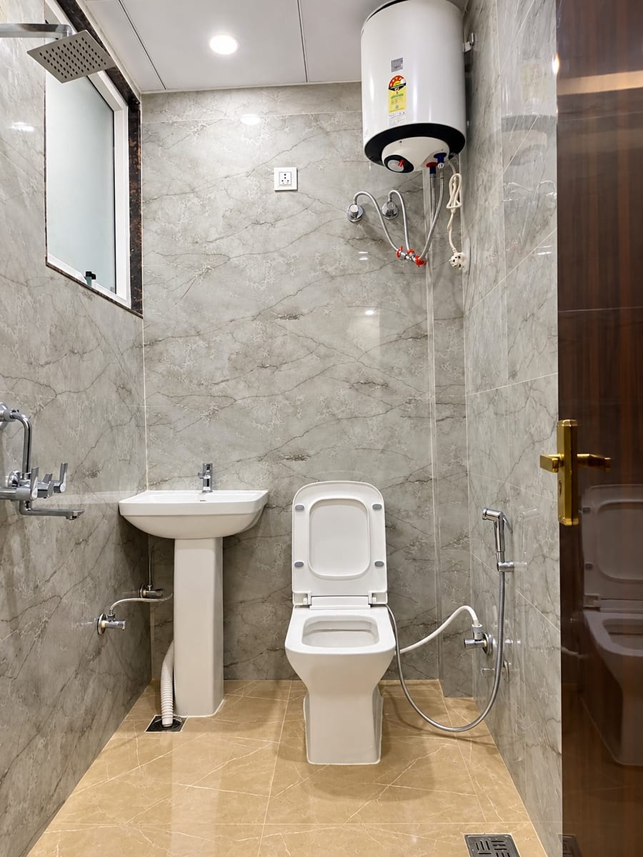 Bathroom with grey marble-look tiles, a wash basin and a shower at Lime Tree Hotel, Vrindavan