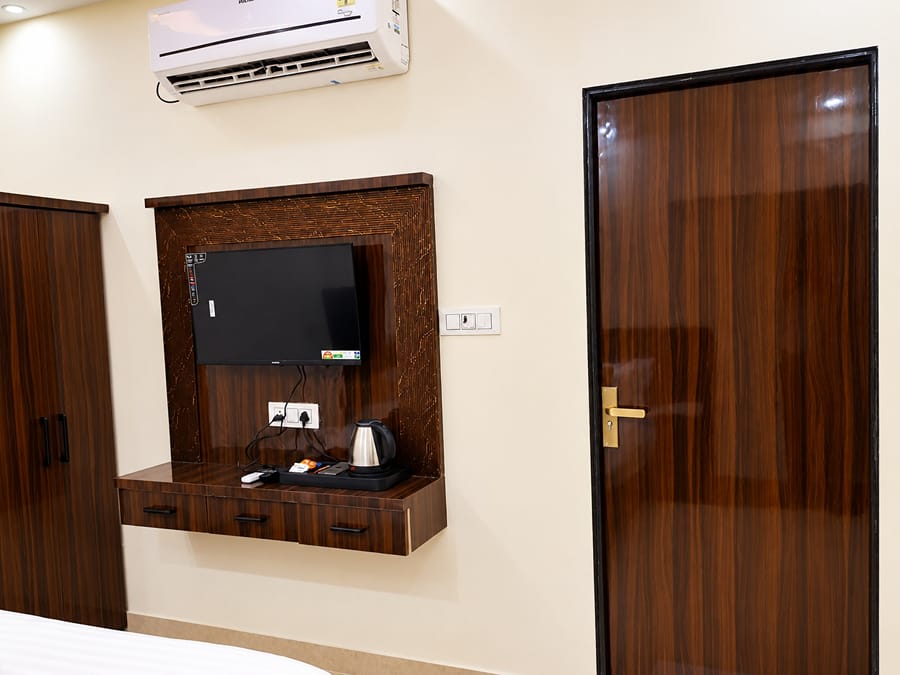 Deluxe Room TV unit with a kettle beside the door at Lime Tree Hotel, Vrindavan