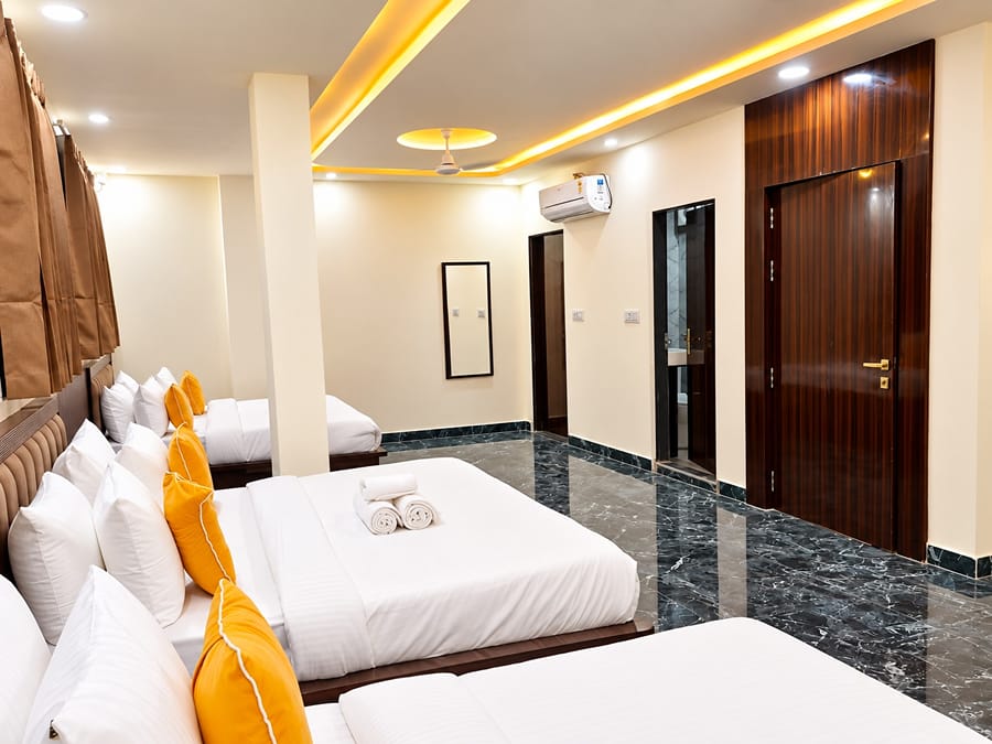 Family Suite beds with yellow cushions and a wardrobe at Lime Tree Hotel, Vrindavan