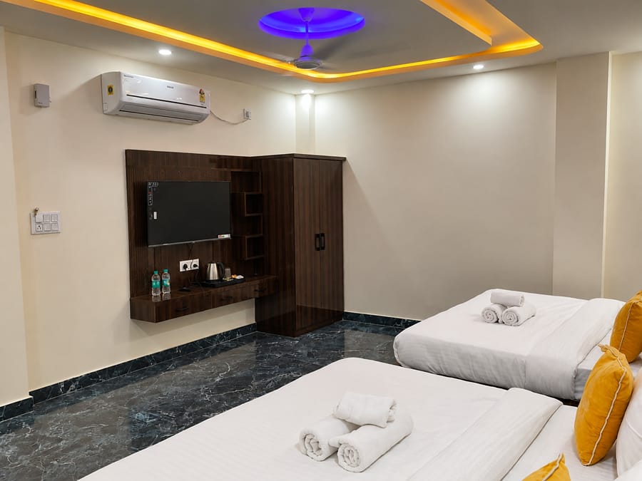 Family Suite TV unit and air conditioner beside the beds at Lime Tree Hotel, Vrindavan