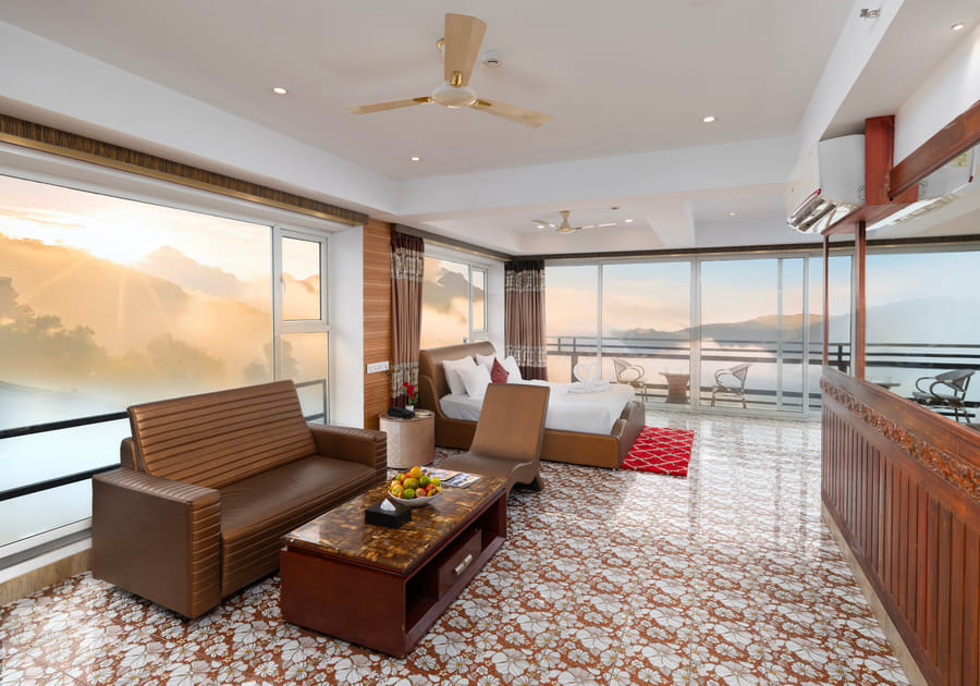Jacuzzi 180 Degree Suite at Parakkat Nature Resort Munnar with private heated circular whirlpool jacuzzi positioned beside glass walls looking over rolling clouds and tea plantations