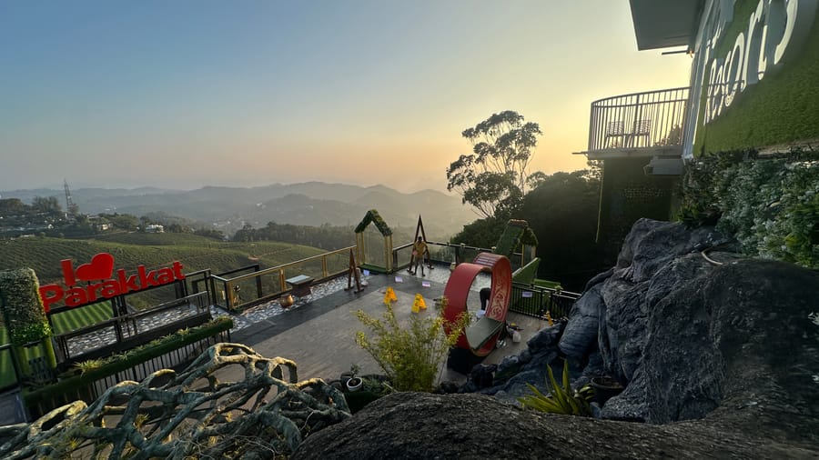 Luxury elevated Tree House AC Room at Parakkat Nature Resort Munnar nestled among high canopy trees overlooking panoramic tea hills with large glass windows and handcrafted wooden interior