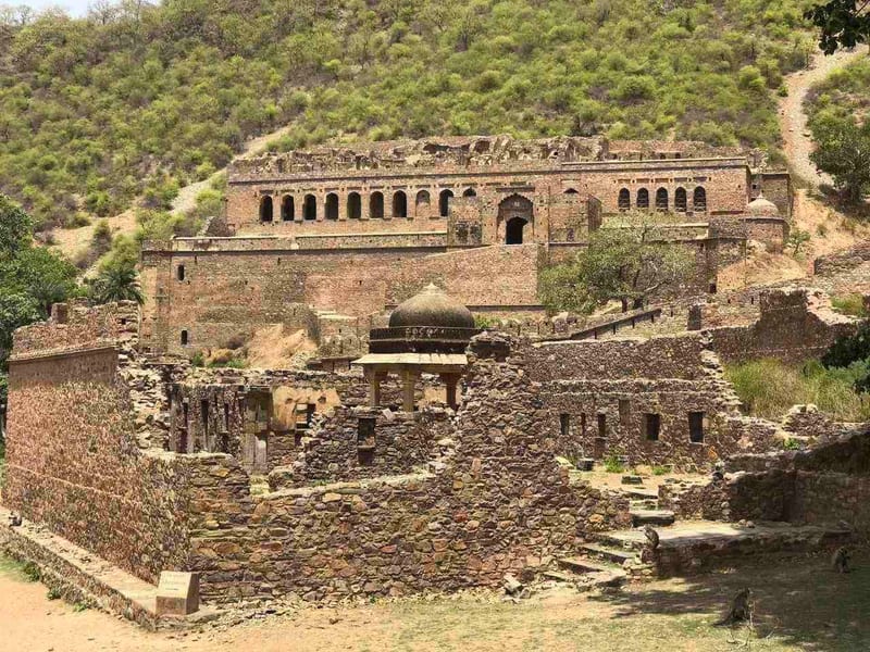 An overview of Bhangarh Fort with massive walls stretching across a hilltop - Utsav Camp Sariska