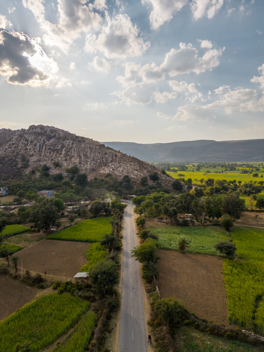 The road to Tehla running between green fields towards the hills