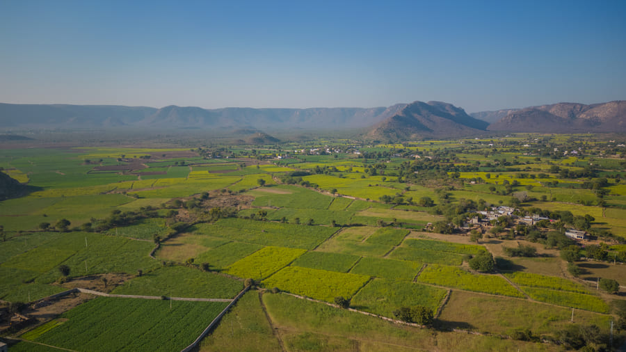Village farmland spread across the valley below the hills