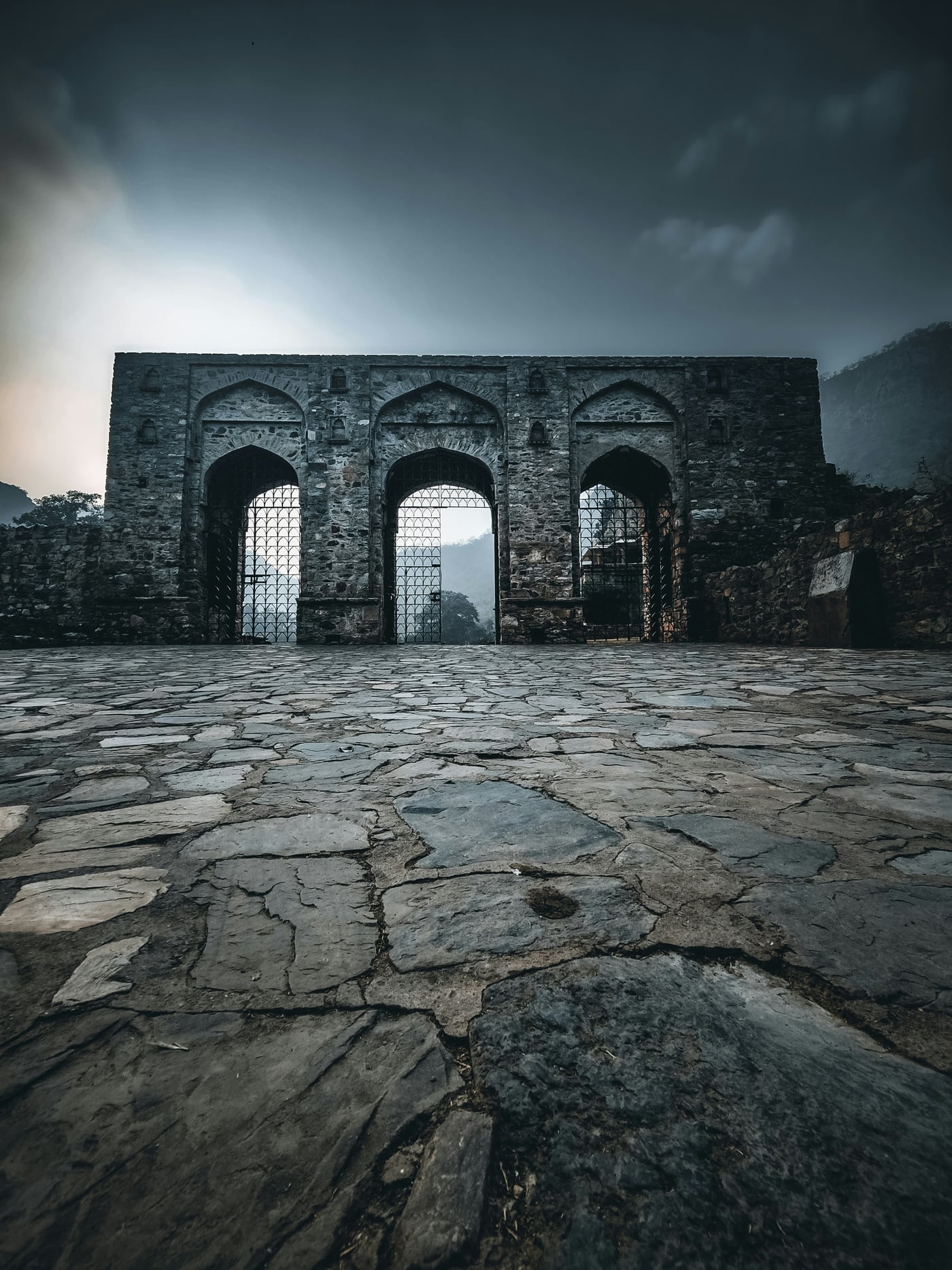 An overview of a fort with cobbled stone pathway and arched entrance in Alwar - It is one of the most visited tourist attractions in Alwar.