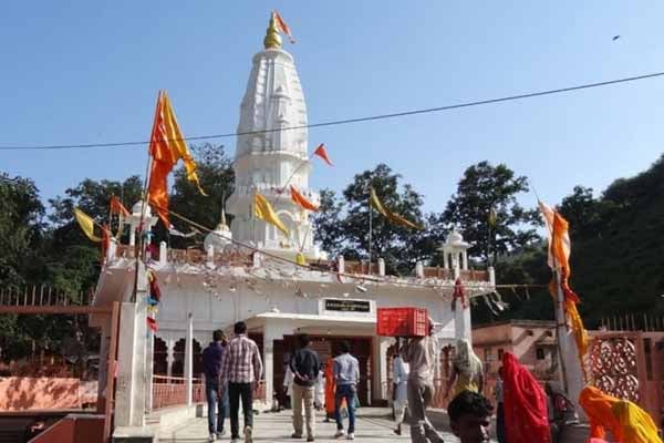 A Hindu temple with flags and decorations stands at an entrance.