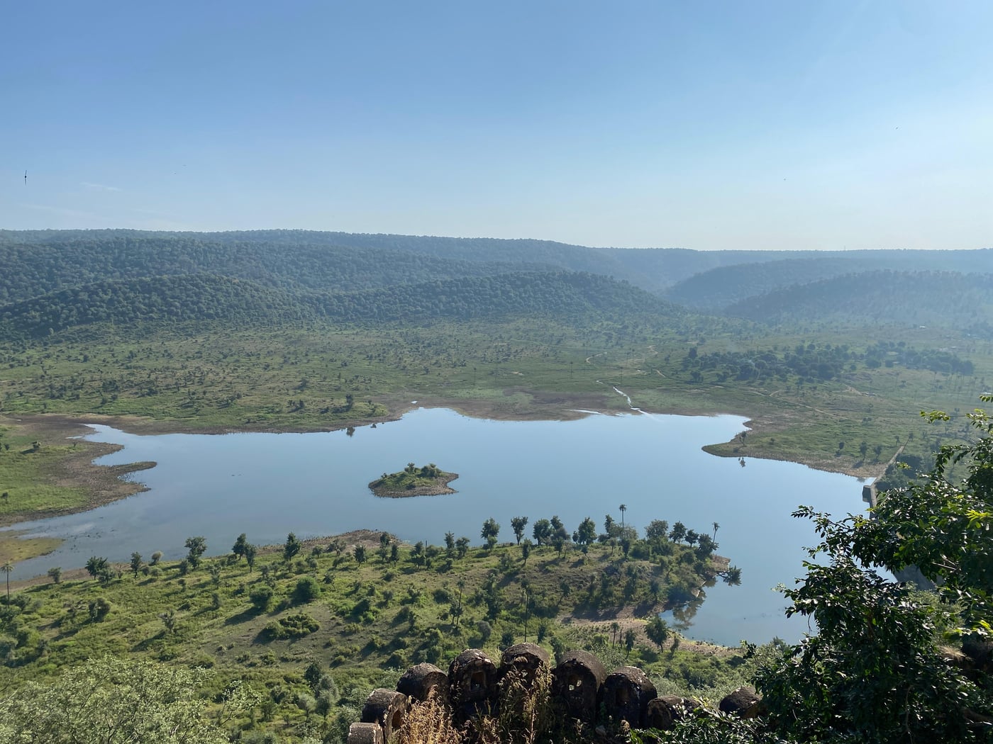 Aerial view image of a dam with water and greenery - Utsav Camp Sariska