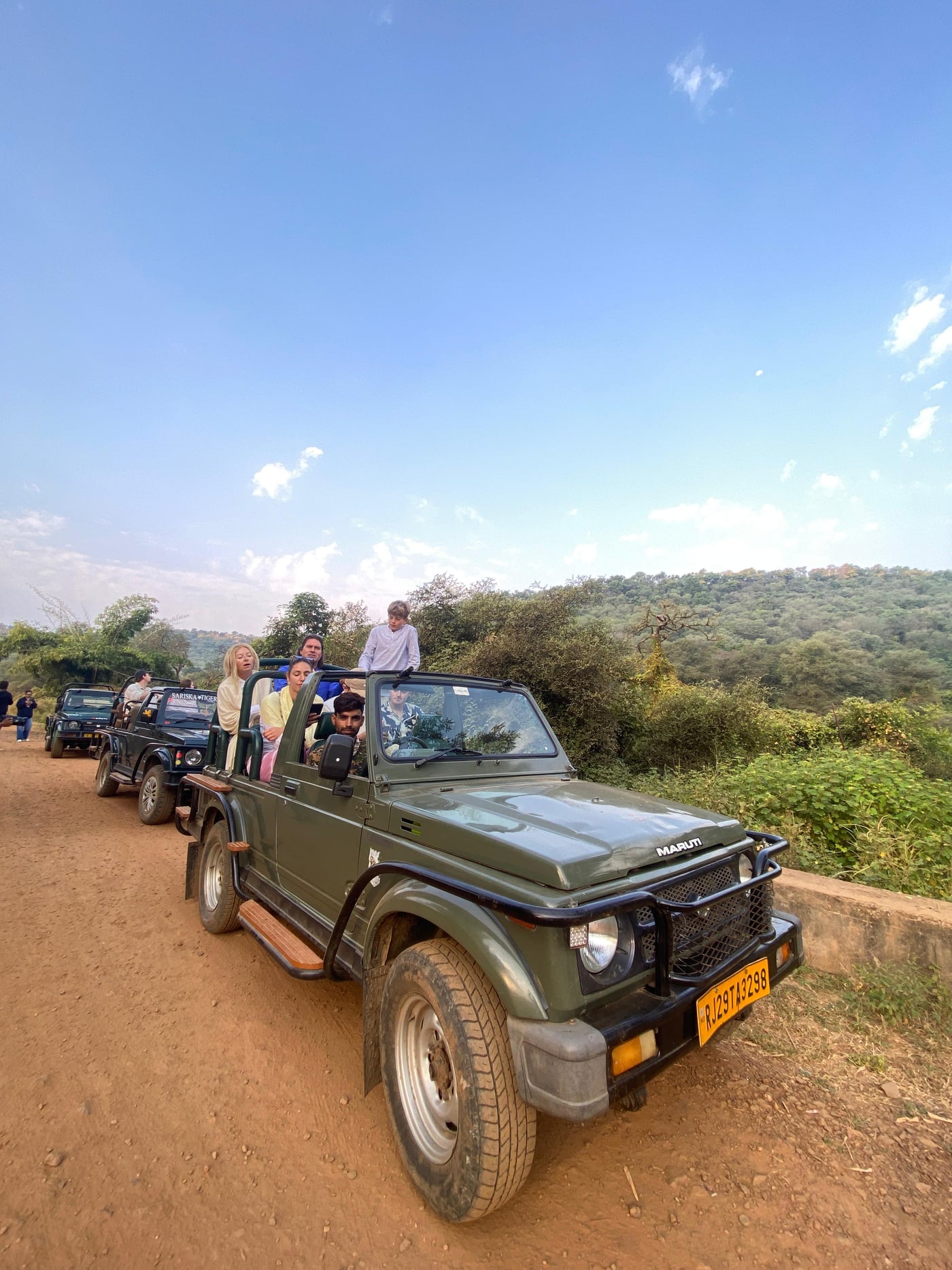 Image featuring few vehicles with the people in it, captured in the day time