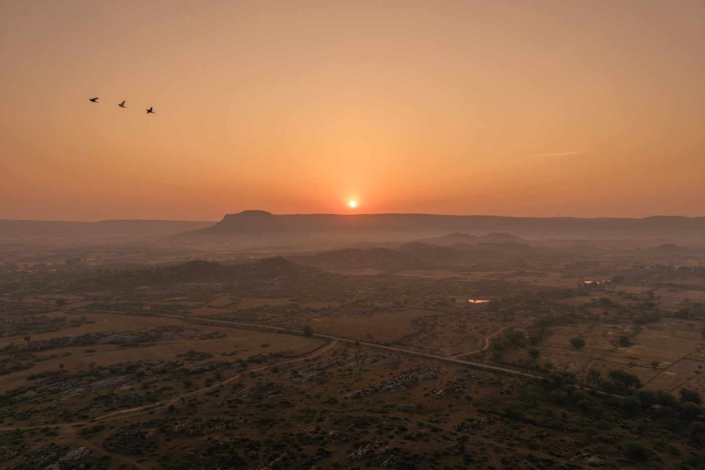 The sun setting over the plains and flat-topped hills of Sariska