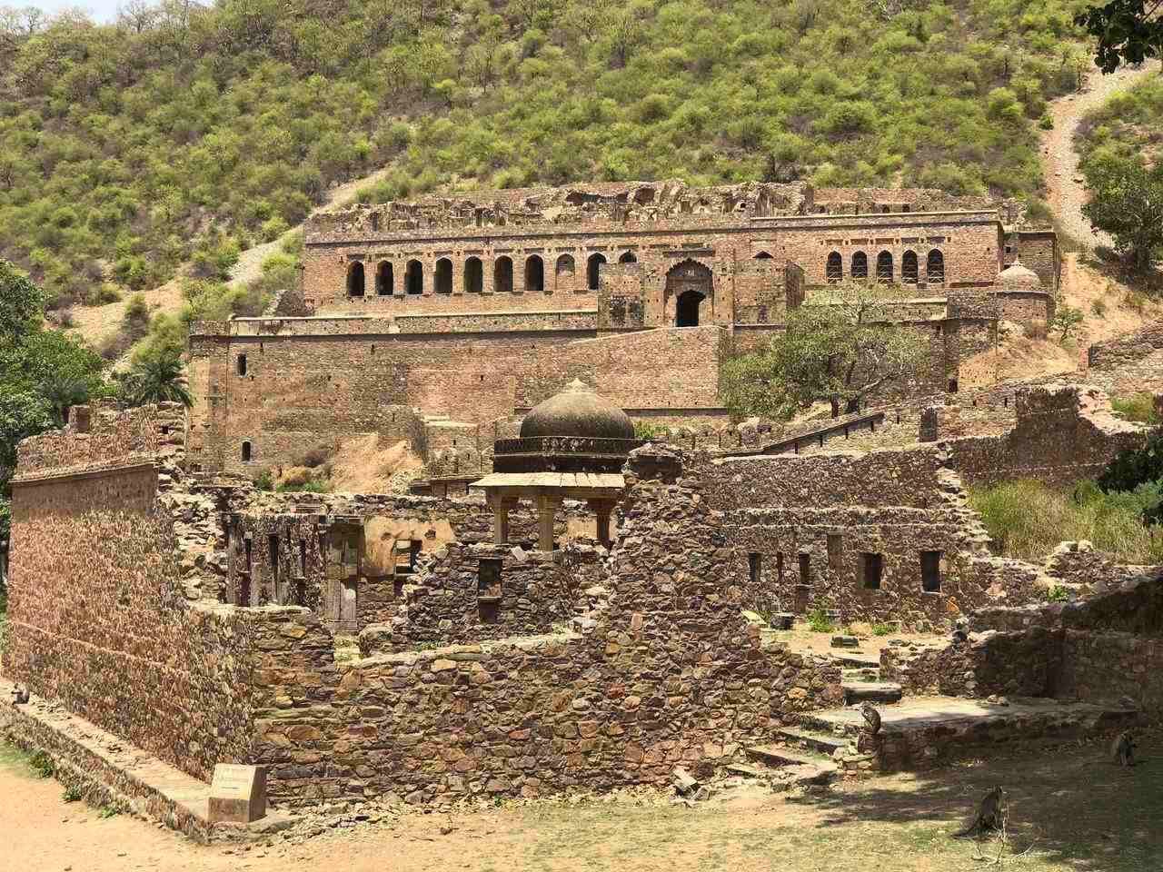 An overview of Bhangarh Fort with massive walls stretching across a hilltop - Utsav Camp Sariska