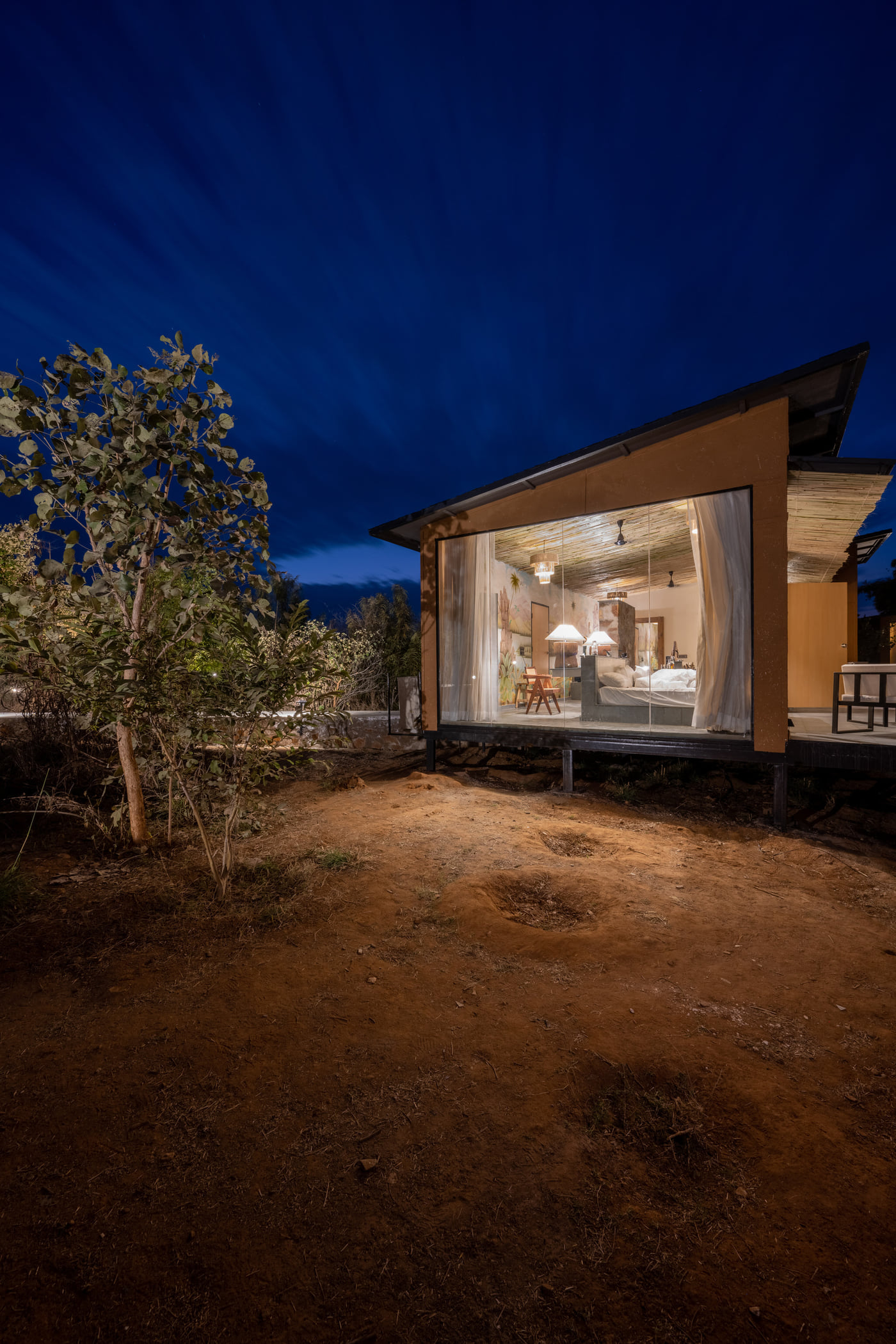 A Forest Bungalow lit from within after dark