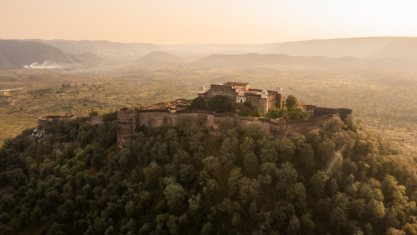 A fort on its wooded hilltop above the valley, seen from the air