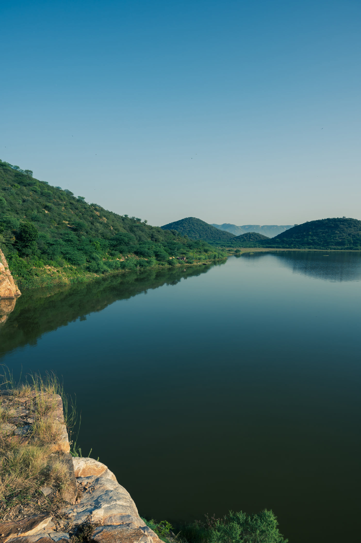 Still water held between wooded hills at Mallana