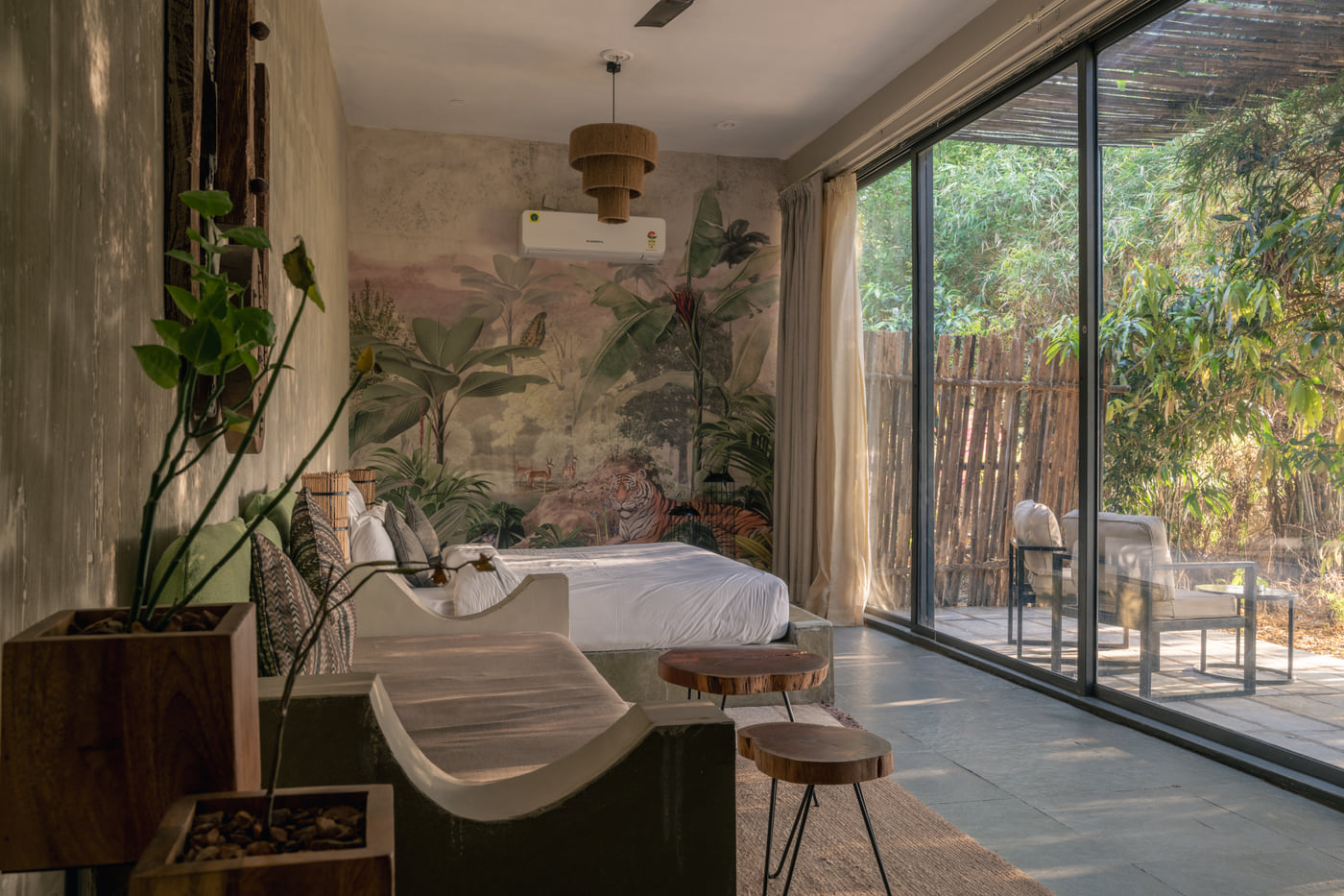 Inside a Stone Cabin, the bed set beside glass doors onto a private sit-out