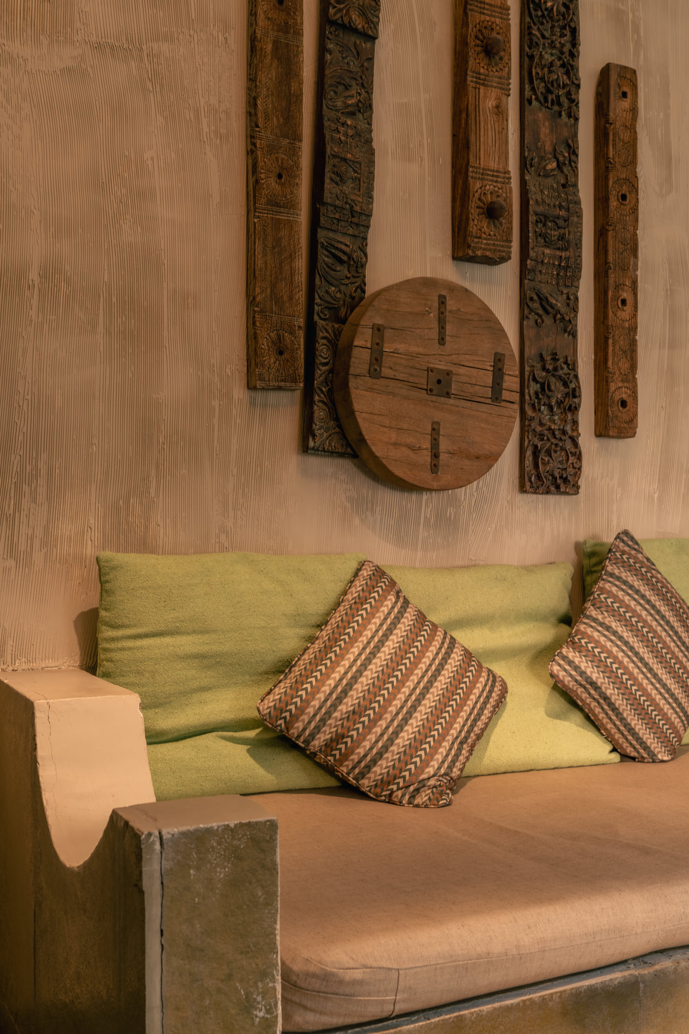Carved wooden wall pieces above the cushioned seating in a Stone Cabin