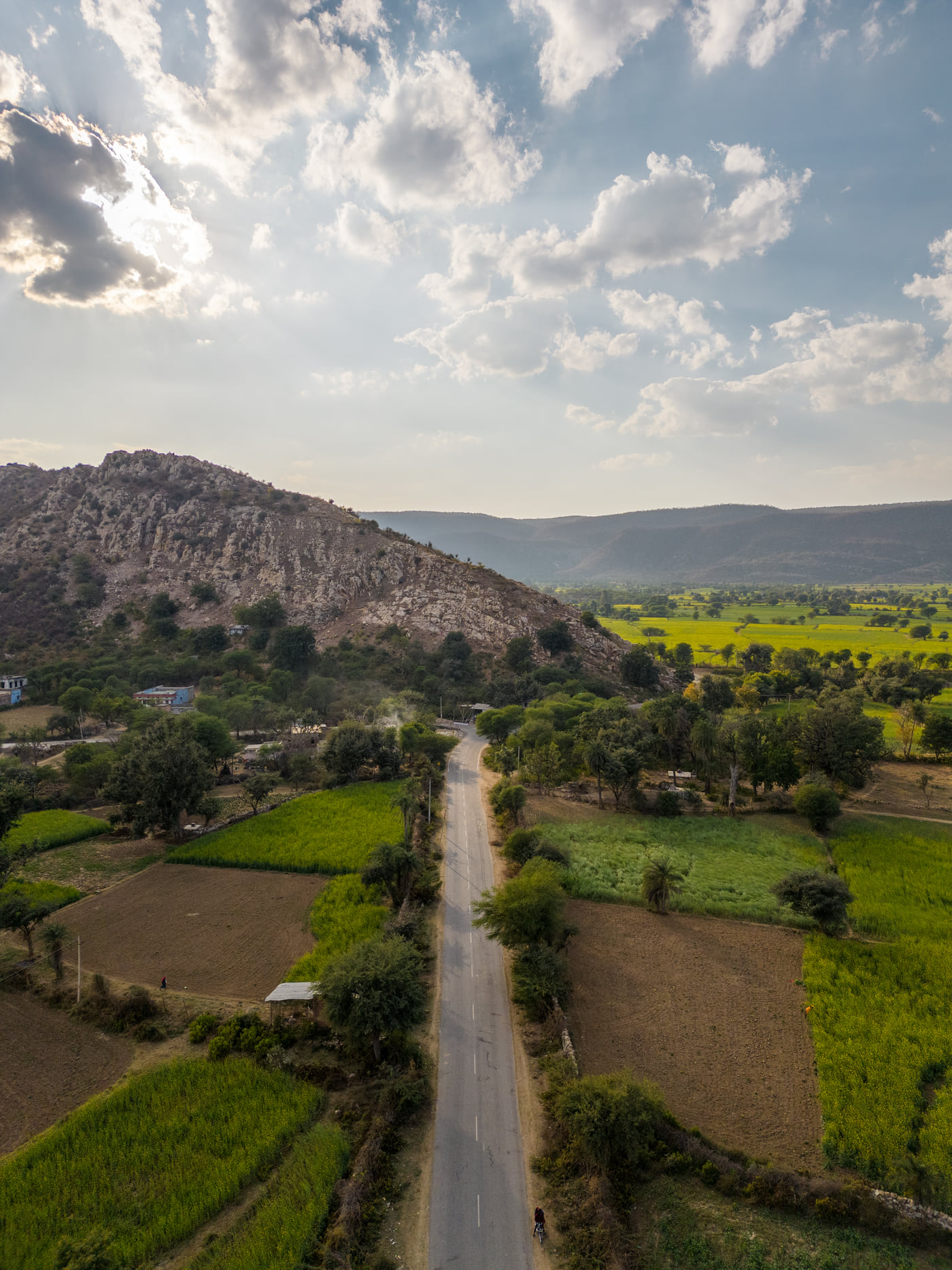 The road to Tehla running between green fields towards the hills