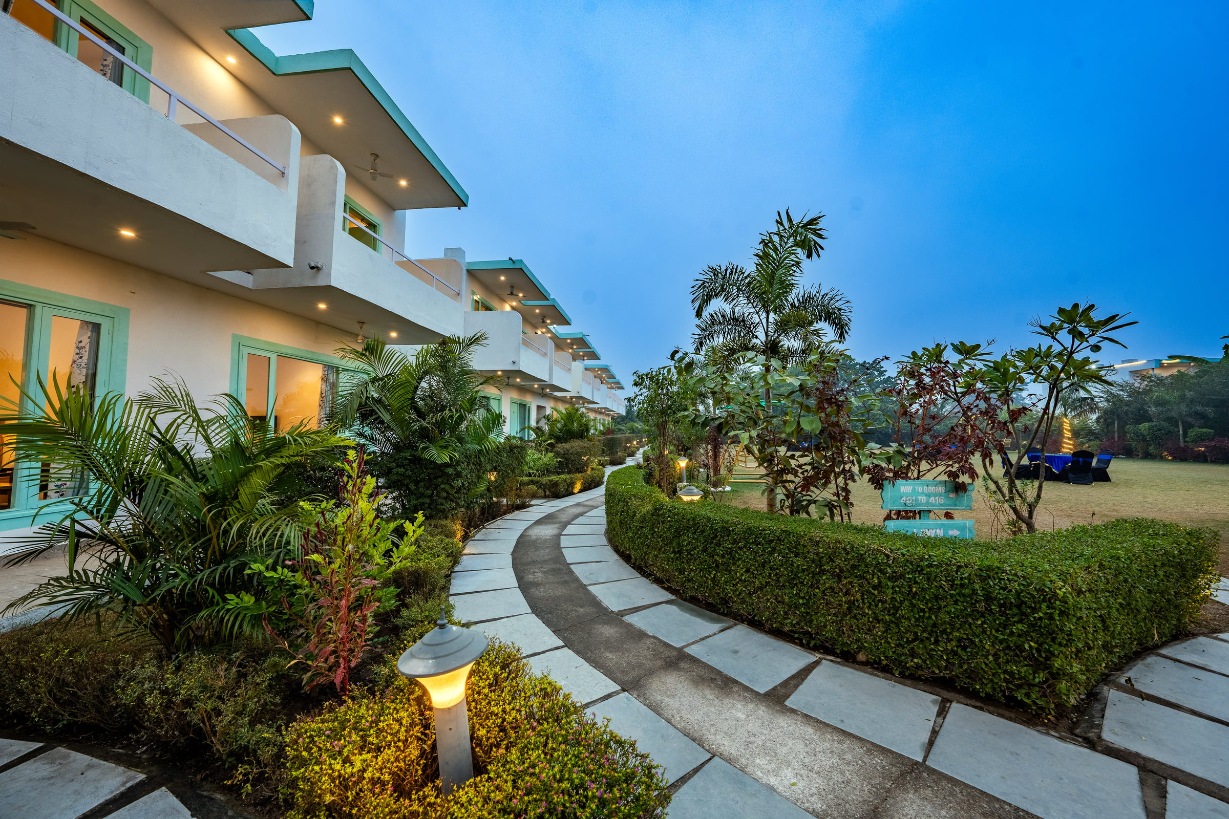 Tree-lined pavement and rooms at Vedikant Resorts The Mallard Corbett