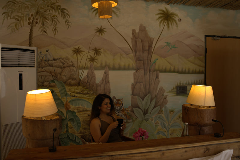 A woman sitting in a room which is well decorated and brightly lit - Utsav Camp Sariska