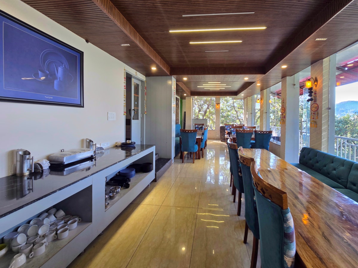 Restaurant terrace with green velvet booths and mountain views at Kavin Highland - The Mall
