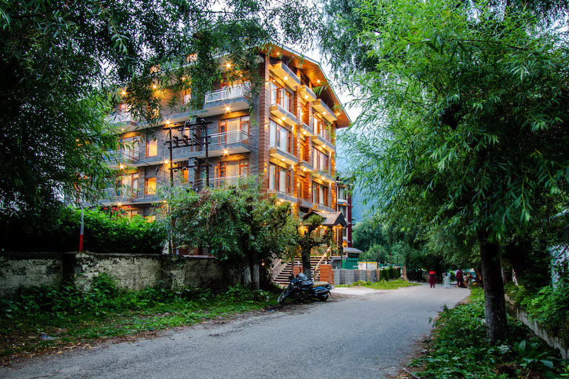 Facade of Hotel Suryansh Regency, Aleo Manali against the Himachal mountains