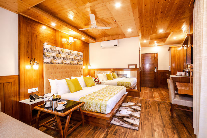 Super Deluxe Room at Hotel Suryansh Regency By Kavin Hotels, Manali, wood-panelled walls, tufted cream headboards, yellow accent pillows