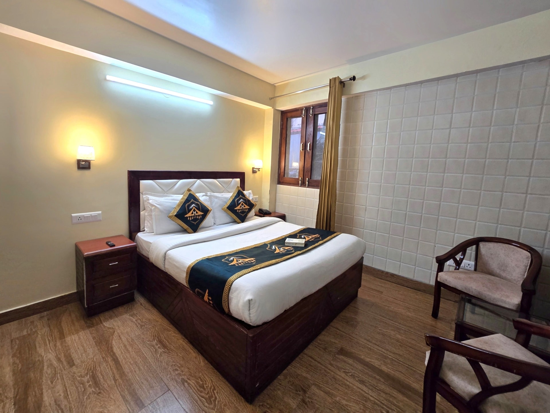Club Room (Non-View) at Kavin Uphar, compact queen bedroom with beige tile feature wall