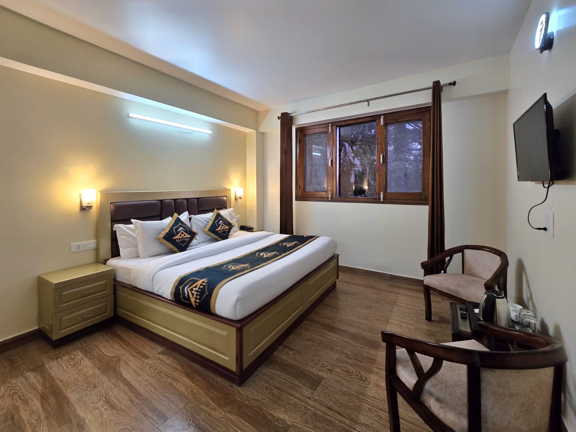 Executive Room (Non-View) at Kavin Uphar, king bed with wall-mounted TV, wardrobe and sitting area