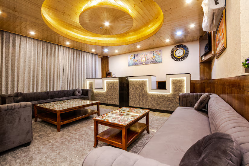 Reception lobby of Hotel Suryansh Regency, Aleo Manali, wooden ceiling and brown sofas