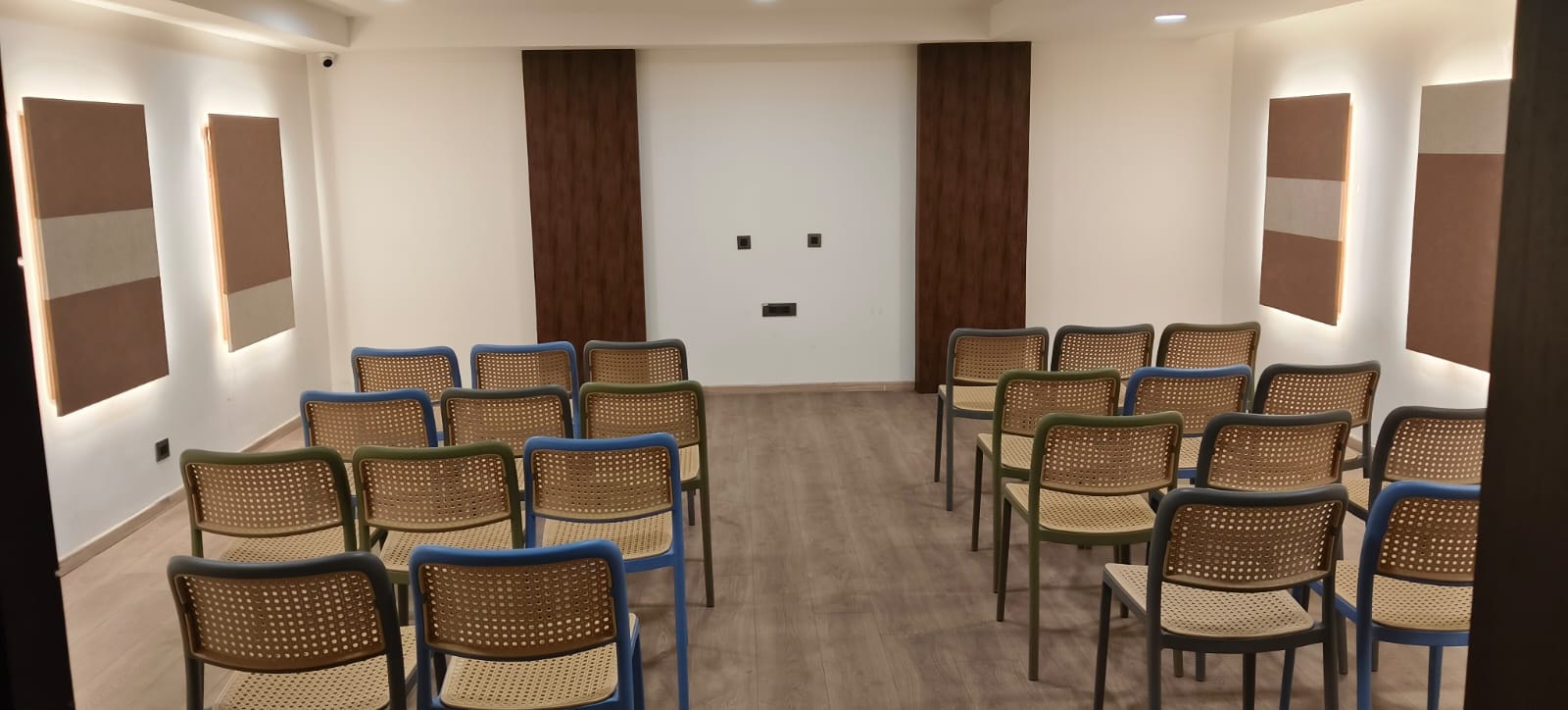 The air-conditioned banquet hall arranged theatre-style with rows of cane chairs and a central aisle at Rossedale Suites & Hotel in Peelamedu, Coimbatore