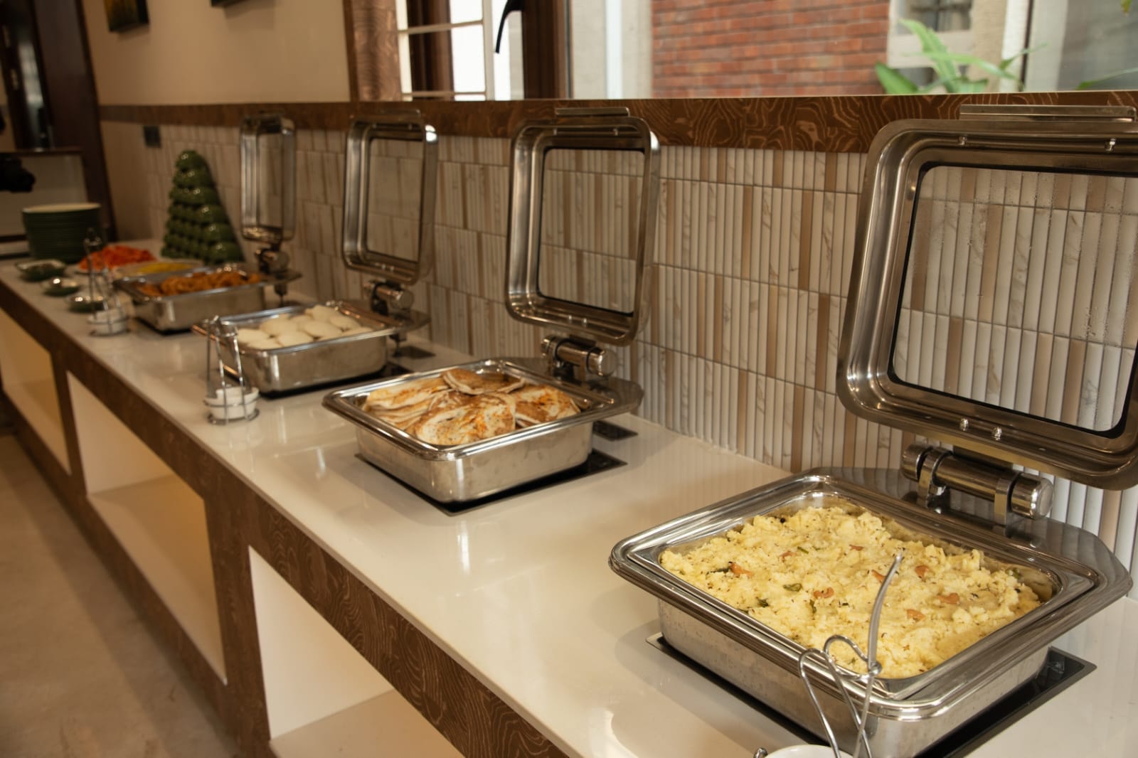Chafing dishes lined along the buffet counter in the Café de Rosse dining hall at Rossedale Suites & Hotel in Peelamedu, Coimbatore