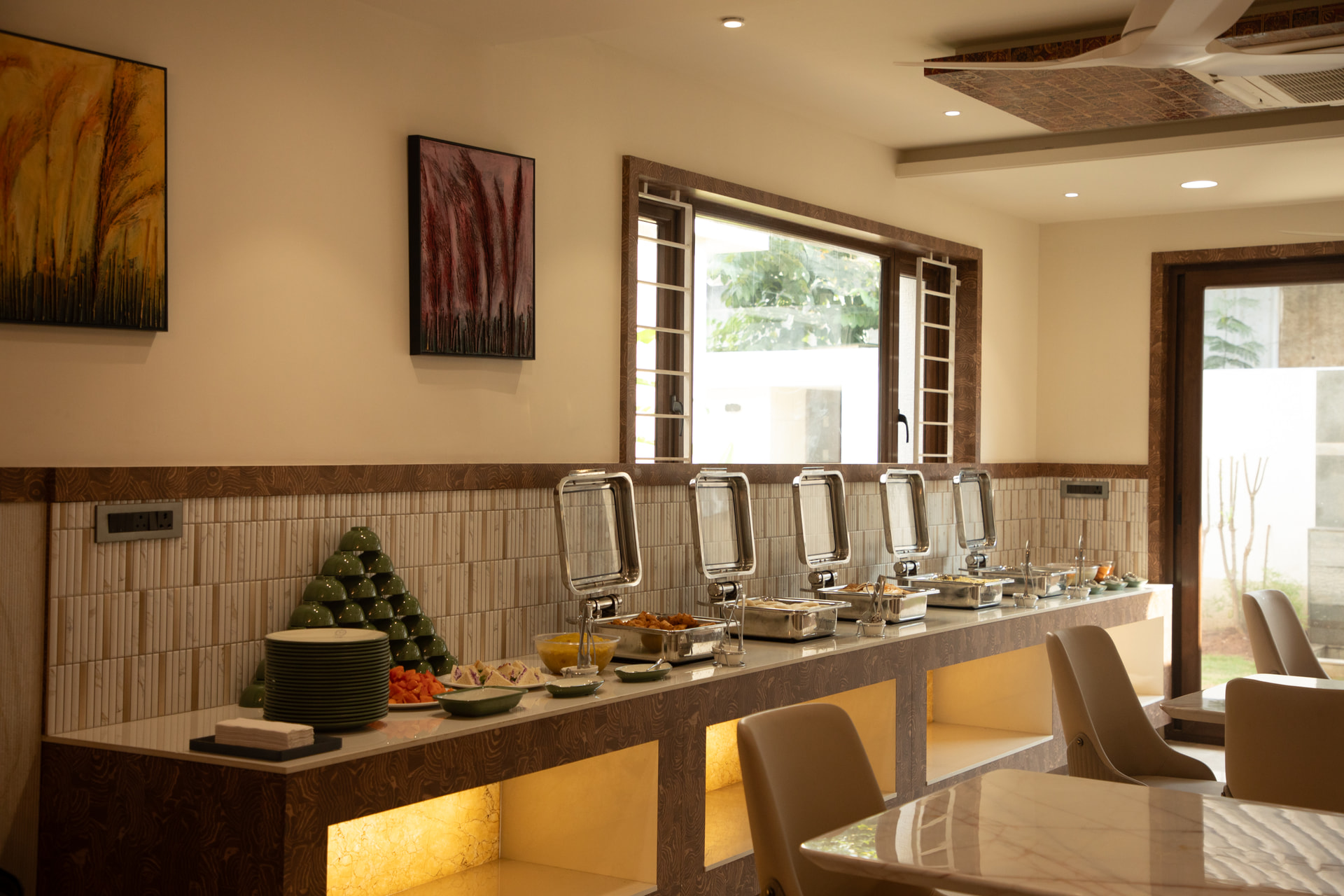 Warm wood tables set in the in-house multi-cuisine restaurant at Rossedale Suites & Hotel in Peelamedu, Coimbatore