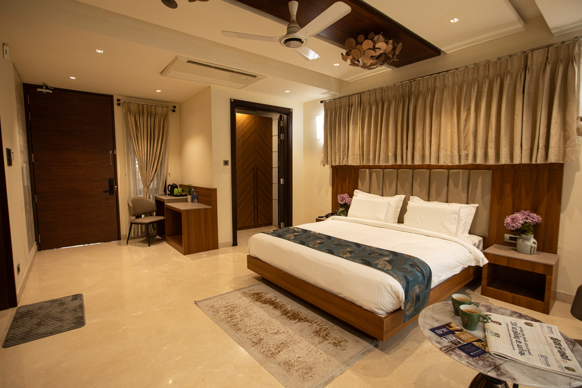 A king-size bed and bedside detailing in the Executive Kitchenette at Rossedale Suites & Hotel in Peelamedu, Coimbatore