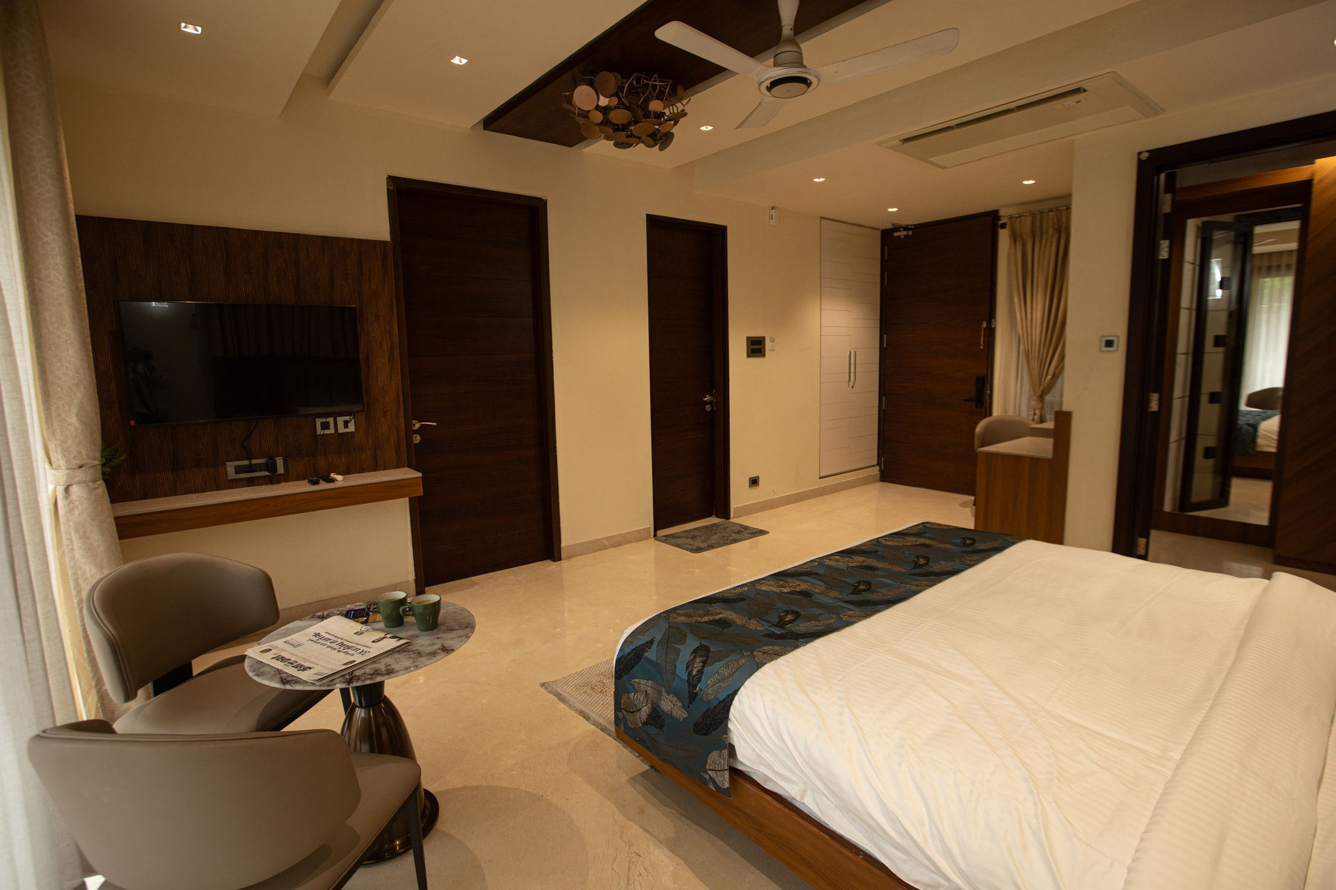 A seating area and wall-mounted TV in the Executive Kitchenette at Rossedale Suites & Hotel in Peelamedu, Coimbatore