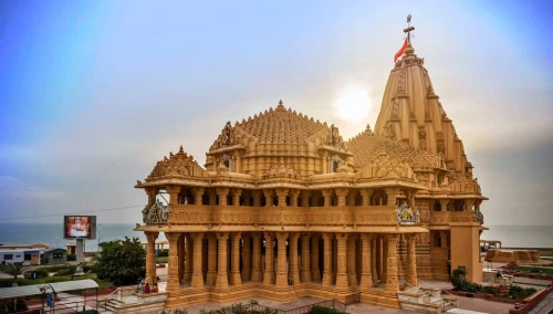 A Dwarka temple featuring pillared architecture, and the top of the temple has religious flags.