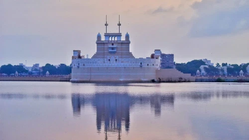A huge monumental building located near the bank of a river or lake.