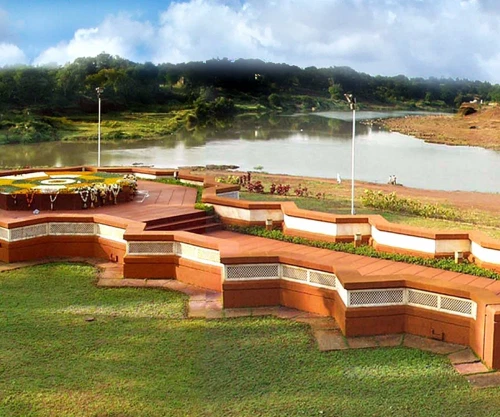 A seating area near the lakeside featuring decorated brick seats and flower gardens.