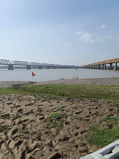 A riverside featuring two bridges adjacent to each other across the river.