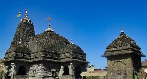 Old and weathered temple-like architecture, and each one has a religious flag on top of the structure.