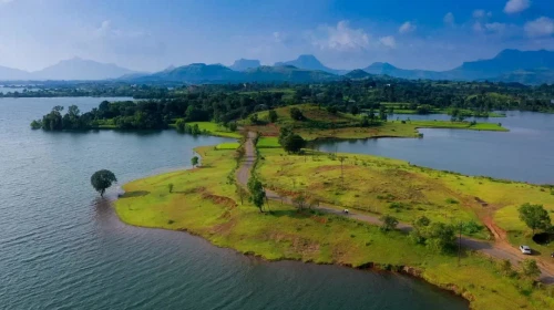 A green land with grass and trees surrounded by water body on all sides.