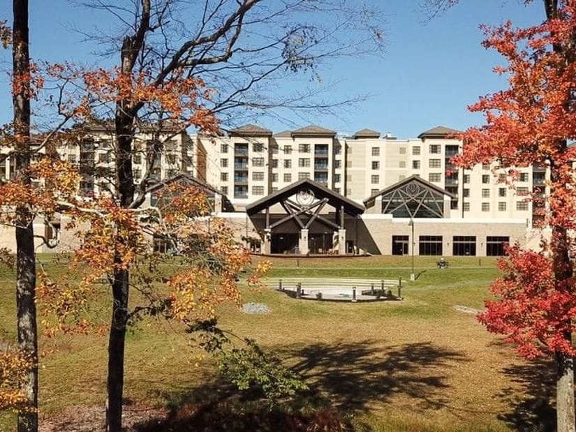 The YO1 Longevity & Health Resorts building in the Catskills, framed by red and orange autumn trees