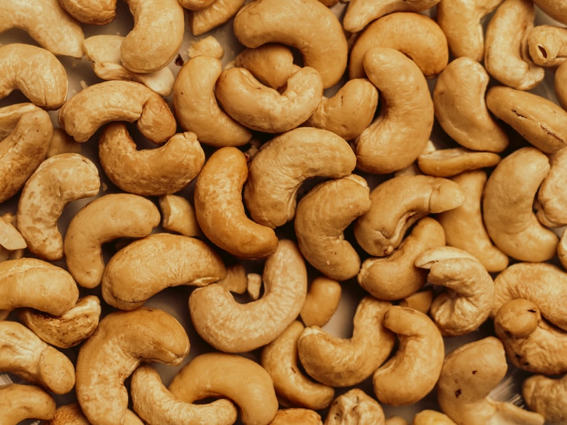 Close-up of whole cashew nuts piled together, seen from above