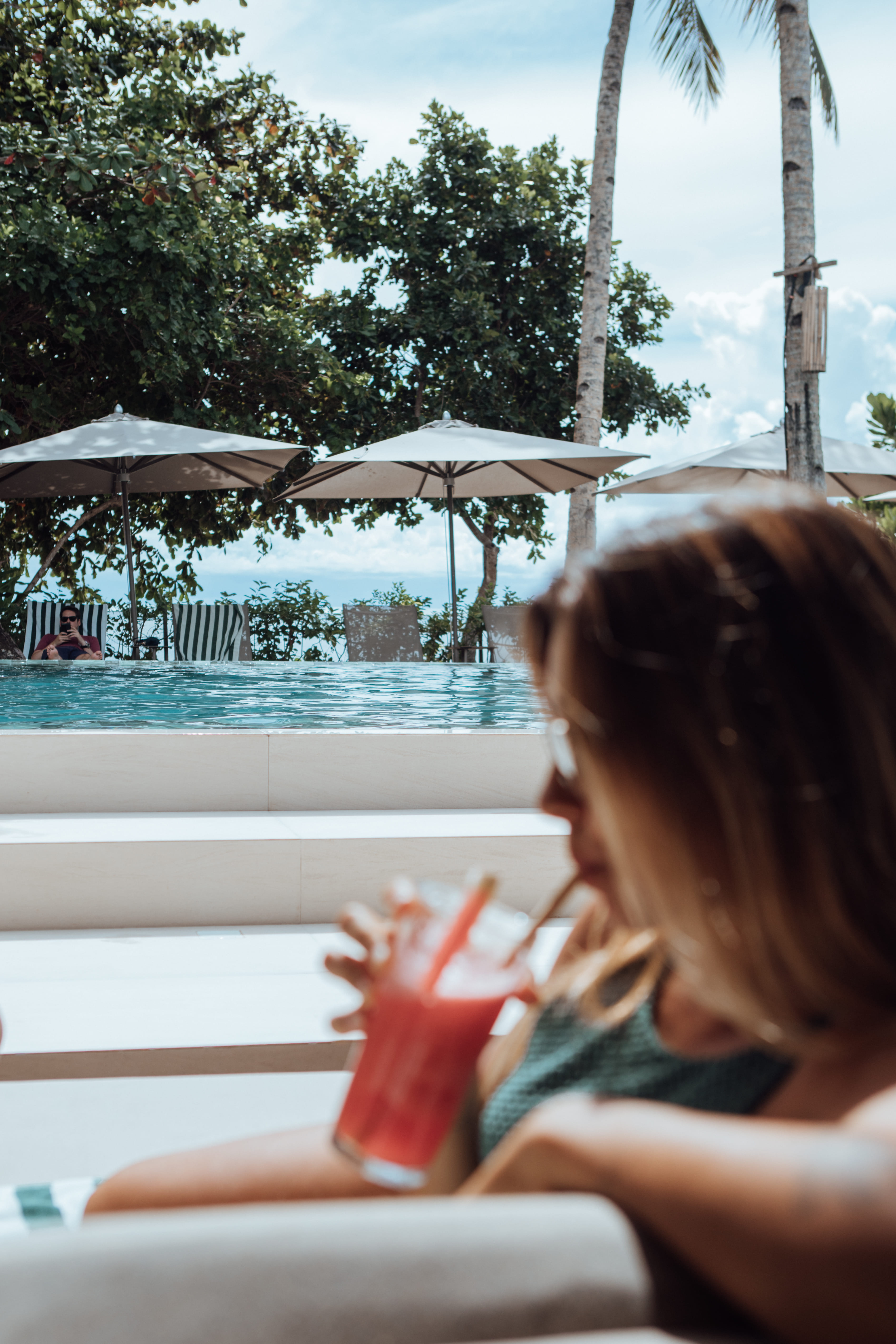Woman drinking a red poolside cocktail at Bravo Beach Resort Siargao