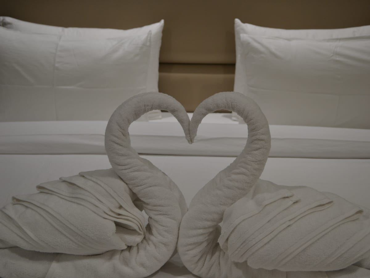 Towels folded into swans on a made-up bed at Signum Tathastu Boutique Hotel, Haridwar