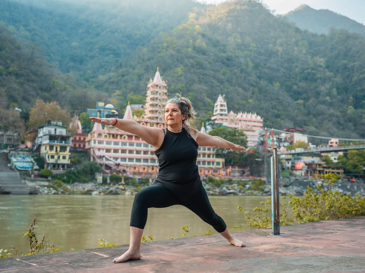 A yoga session on a riverside terrace, with temples across the water