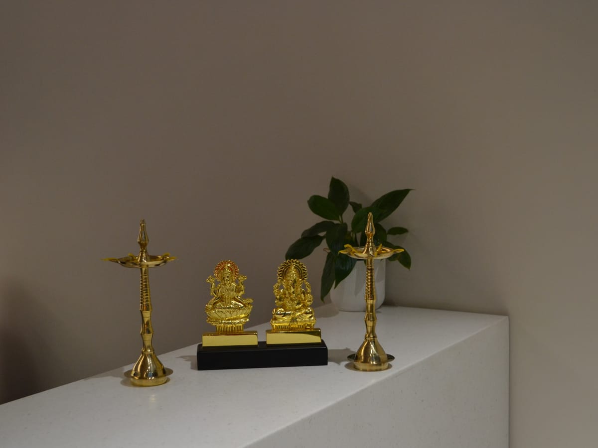 Brass lamps and deities on the lobby console at Signum Tathastu Boutique Hotel, Haridwar