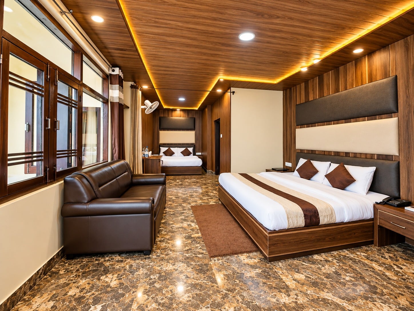 Family Suite at Hotel Himdhara with a sofa by the windows and two beds beyond