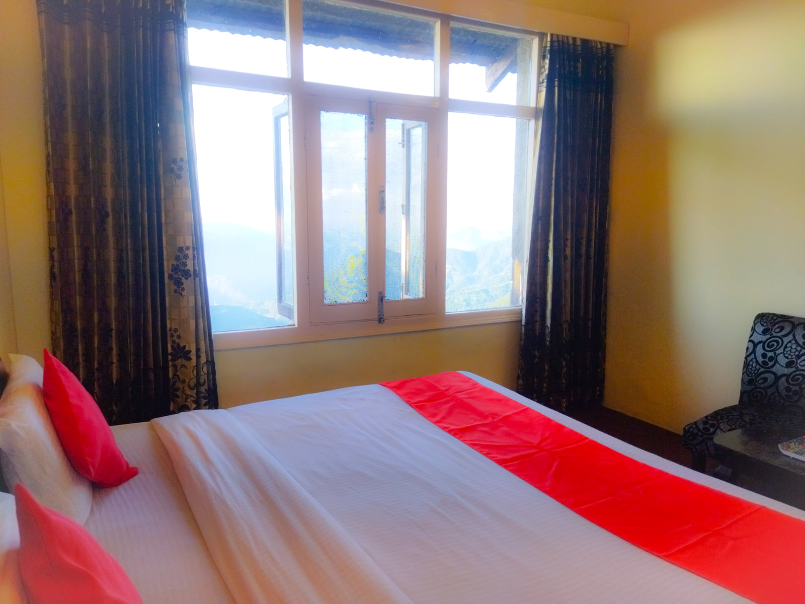 Deluxe Room bed by the window, Hotel Surya Resort
