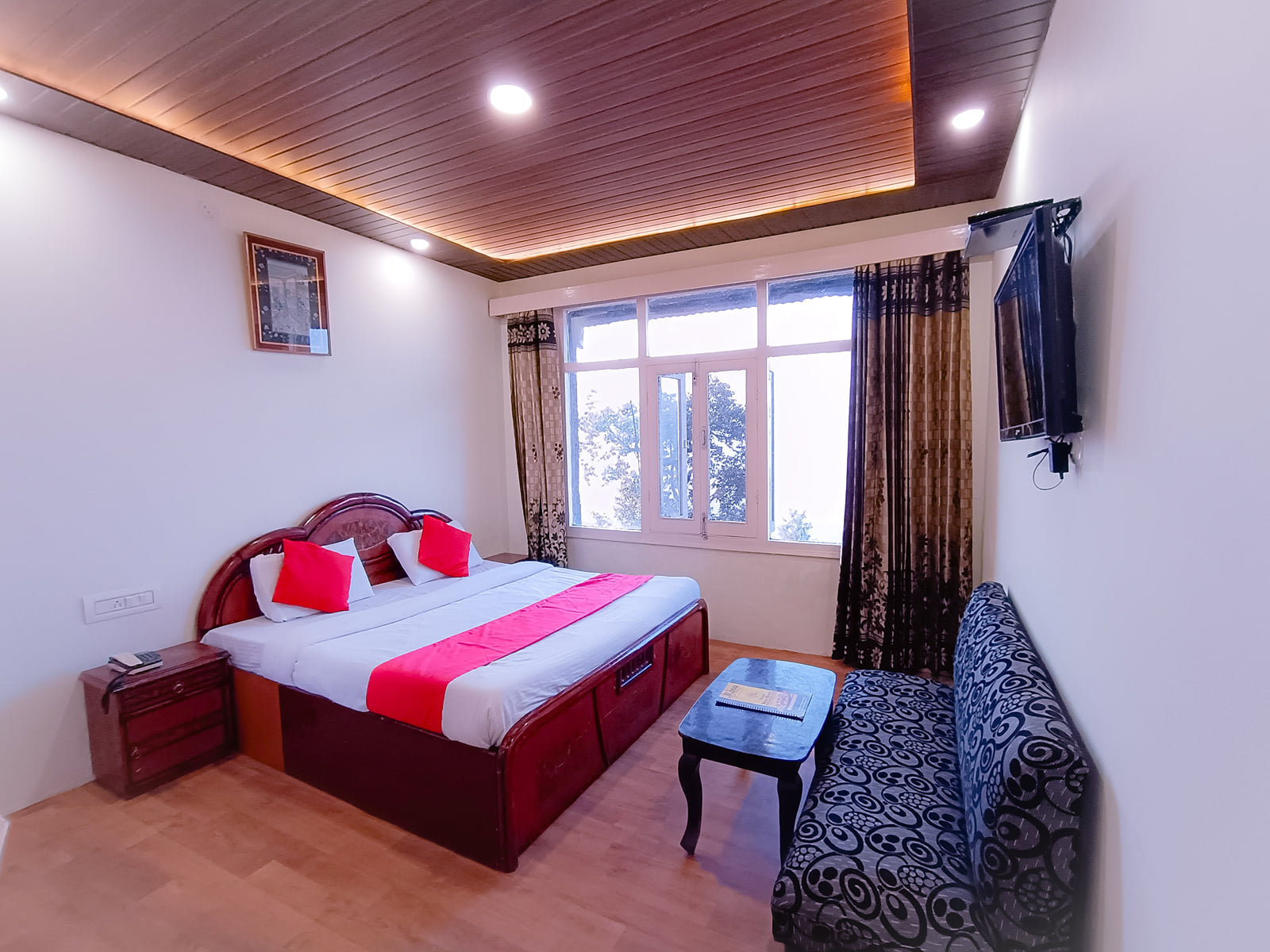 A guest room with wood-panelled ceiling at JPT Hotels, Dalhousie