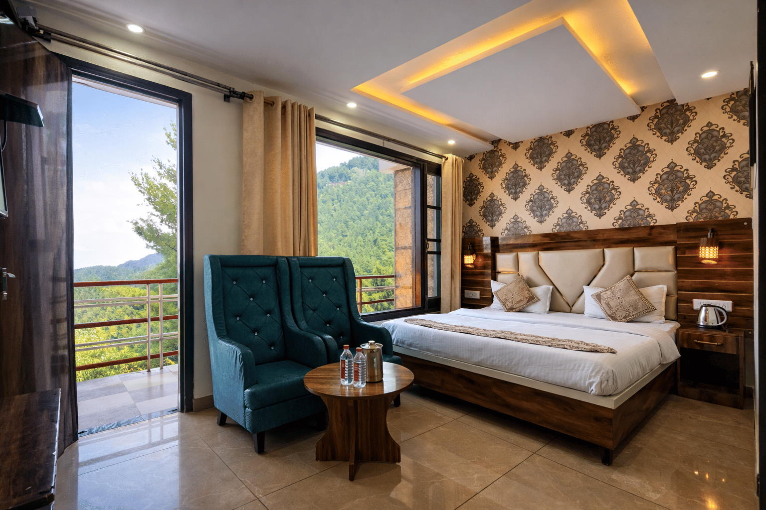 A guest room with blue armchairs and a hill view at JPT Hotels